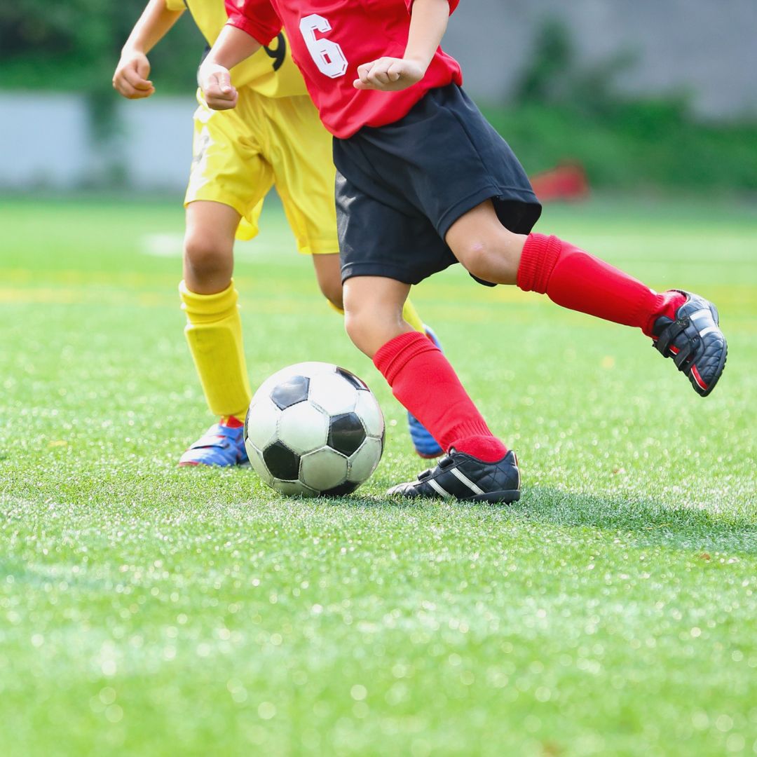Zwei kleine Kinder spielen Fussball